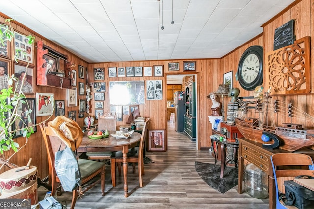 dining space featuring hardwood / wood-style flooring and wood walls