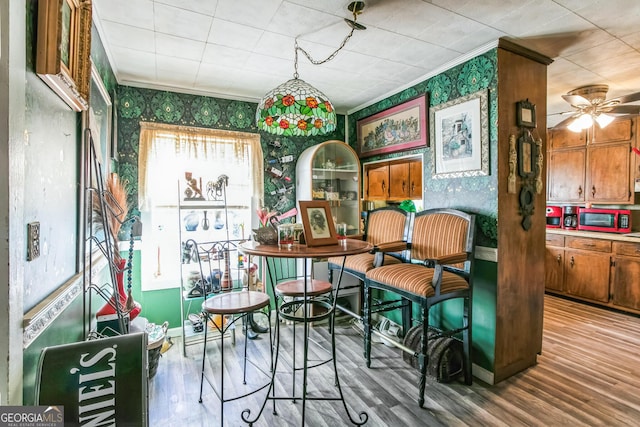 interior space featuring hardwood / wood-style flooring, ceiling fan, and ornamental molding