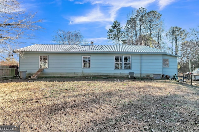 rear view of property featuring a yard