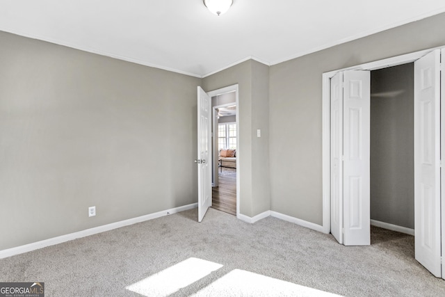 unfurnished bedroom with light carpet and a closet