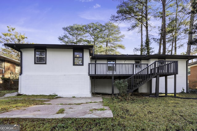 rear view of house with a deck and a yard