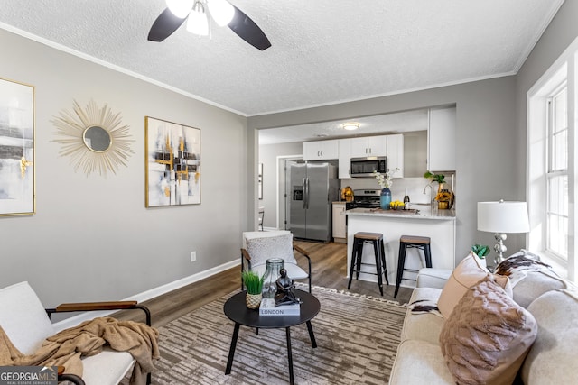 living room with a textured ceiling, dark hardwood / wood-style flooring, and ceiling fan