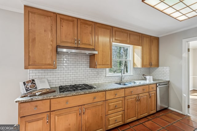 kitchen featuring stainless steel appliances, light stone counters, tasteful backsplash, and sink