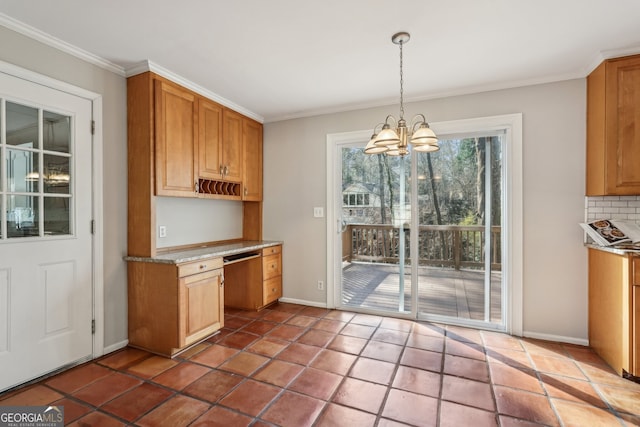 kitchen featuring tasteful backsplash, crown molding, decorative light fixtures, a notable chandelier, and dishwasher