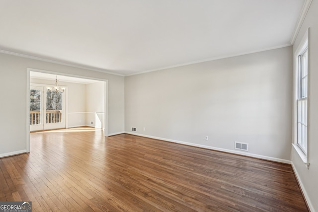 unfurnished room with hardwood / wood-style floors, a notable chandelier, and ornamental molding