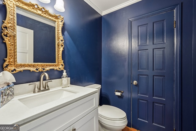 bathroom with vanity, toilet, and ornamental molding