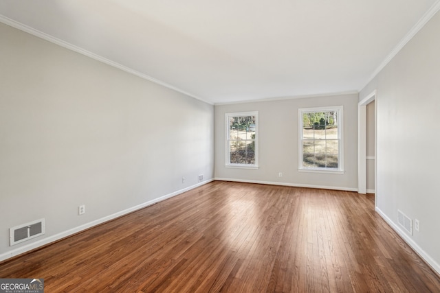 empty room featuring wood-type flooring and ornamental molding