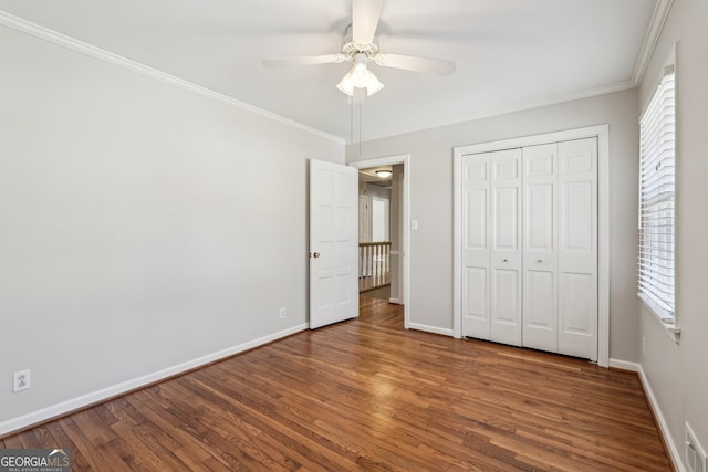 unfurnished bedroom with wood-type flooring, a closet, ceiling fan, and crown molding