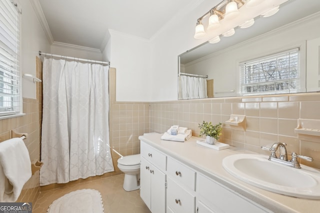 bathroom featuring tile patterned flooring, crown molding, toilet, vanity, and tile walls