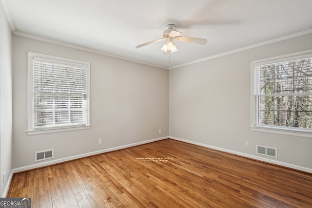 empty room with wood-type flooring, ceiling fan, and crown molding