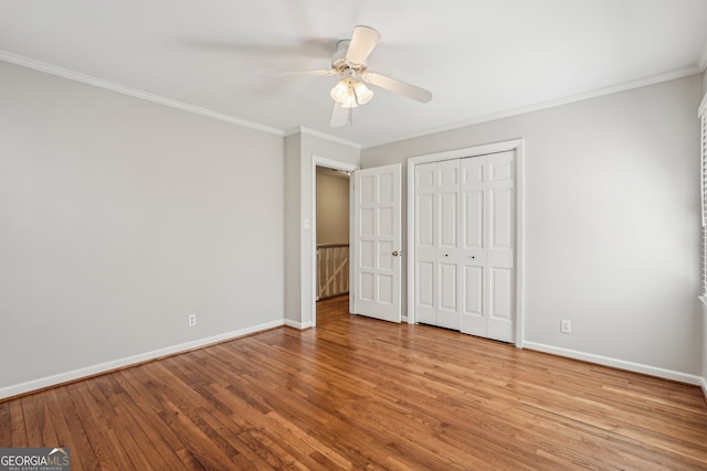 unfurnished bedroom featuring ceiling fan, a closet, ornamental molding, and light hardwood / wood-style flooring