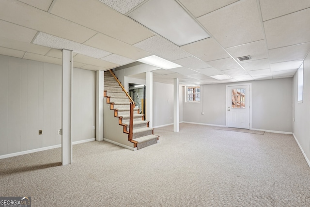 basement featuring light carpet and a drop ceiling