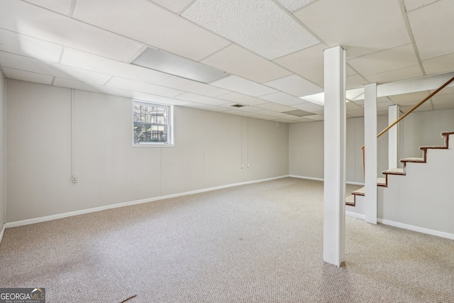 basement with carpet and a paneled ceiling