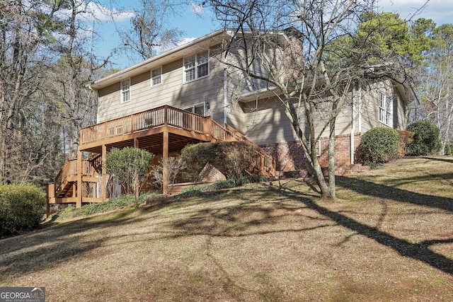 back of house featuring a lawn and a wooden deck