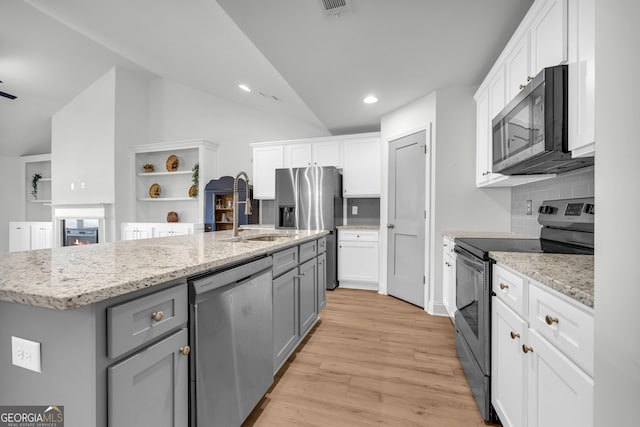 kitchen with white cabinets, gray cabinets, stainless steel appliances, and a center island with sink