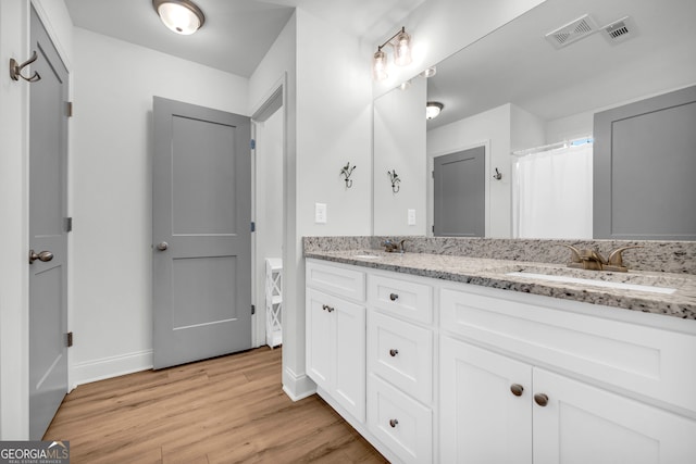 bathroom featuring hardwood / wood-style flooring, vanity, and curtained shower