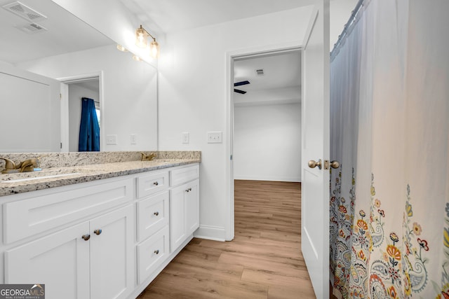 bathroom featuring ceiling fan, hardwood / wood-style floors, and vanity