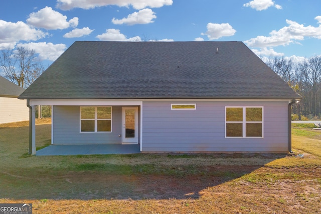 rear view of property featuring a yard and a patio