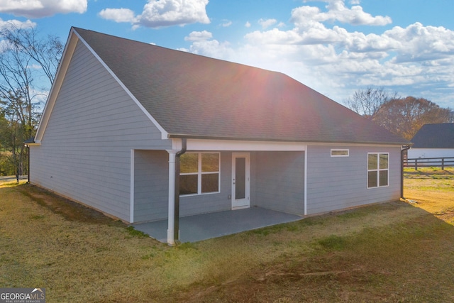 rear view of house with a yard and a patio