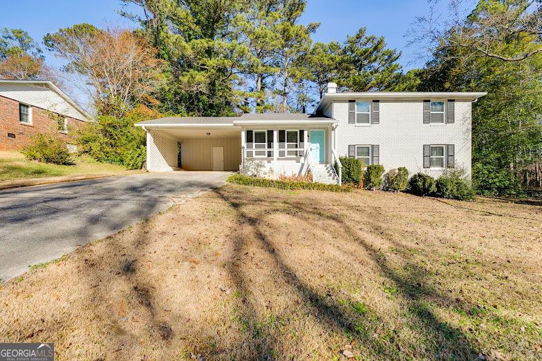 view of front of house with a front lawn and a carport