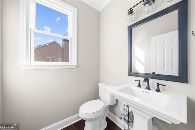 bathroom with hardwood / wood-style floors, crown molding, toilet, and sink