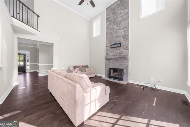 living room featuring crown molding, dark hardwood / wood-style flooring, and a towering ceiling