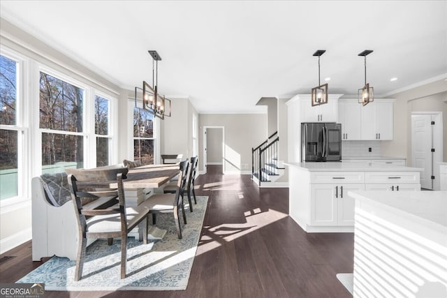 dining room featuring crown molding, dark wood-type flooring, and a healthy amount of sunlight