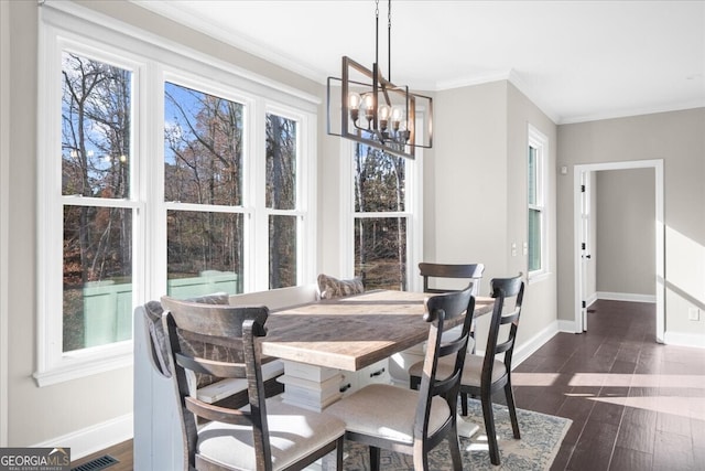 dining room featuring dark hardwood / wood-style flooring, ornamental molding, and an inviting chandelier