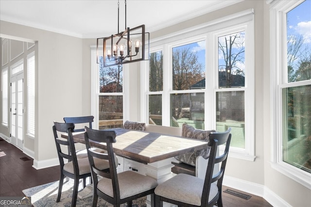 dining room featuring ornamental molding, dark hardwood / wood-style floors, and an inviting chandelier