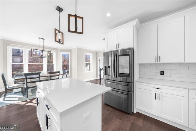 kitchen with stainless steel fridge with ice dispenser, white cabinetry, hanging light fixtures, and a kitchen island