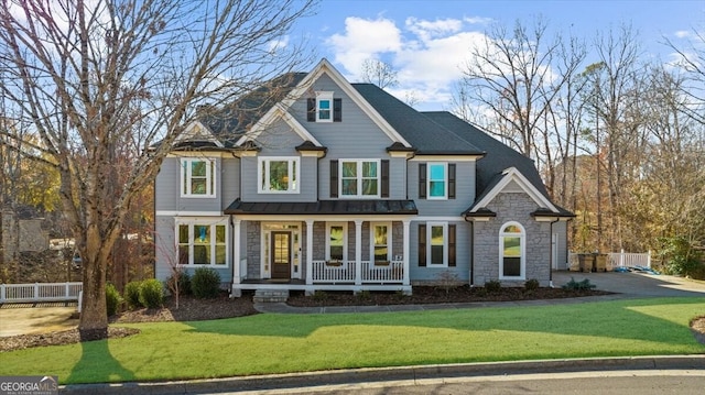 view of front of house with covered porch and a front lawn