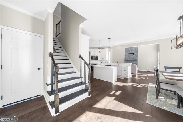 interior space featuring hardwood / wood-style flooring, ornamental molding, sink, and an inviting chandelier