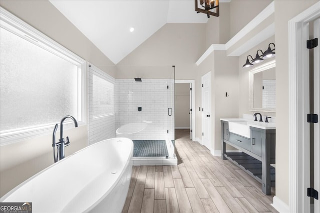 bathroom with vanity, independent shower and bath, and lofted ceiling