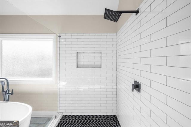 bathroom with tiled shower, tile patterned flooring, and tile walls