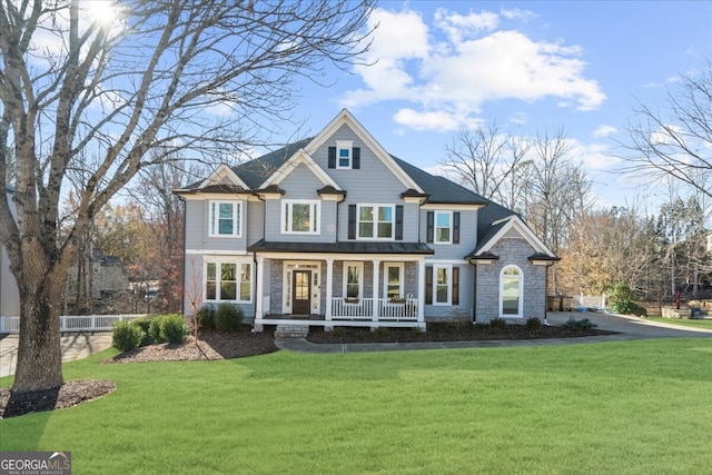 craftsman inspired home featuring covered porch and a front yard