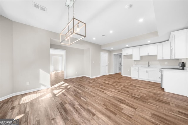 unfurnished living room with light hardwood / wood-style floors and sink