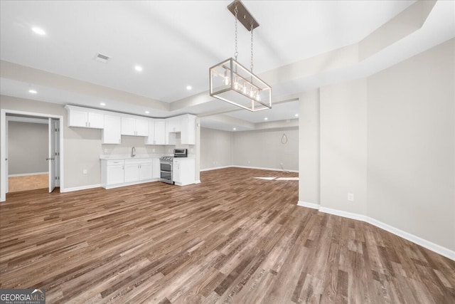 unfurnished living room featuring hardwood / wood-style floors and a raised ceiling