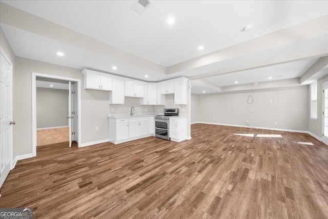 kitchen featuring hardwood / wood-style floors, white cabinetry, and electric stove