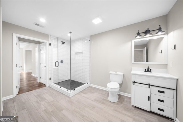 bathroom featuring toilet, vanity, and walk in shower