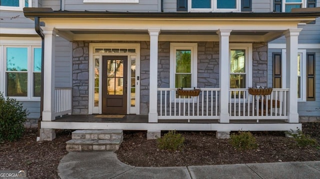 view of exterior entry featuring covered porch