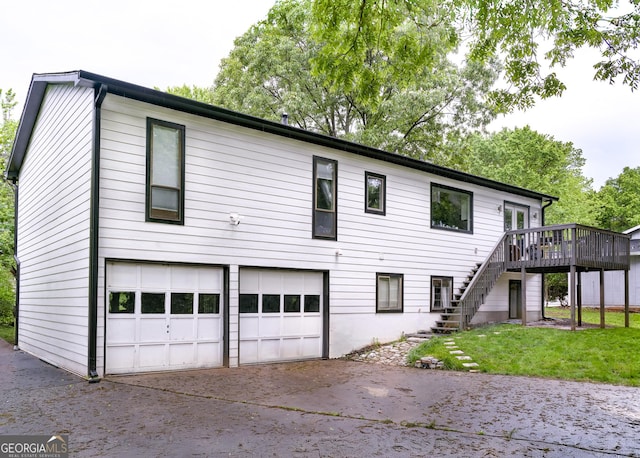 view of front of home with a garage, a wooden deck, and a front lawn