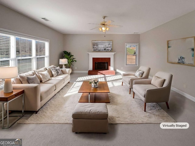 living room with ceiling fan and a fireplace