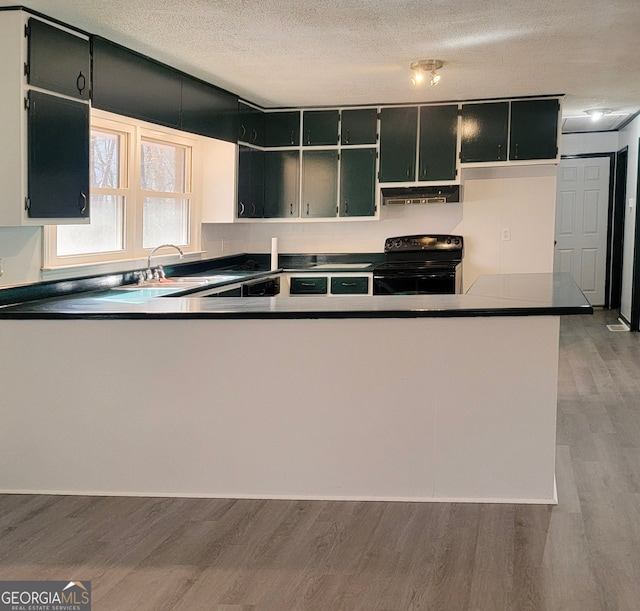 kitchen featuring sink, black range with electric cooktop, light hardwood / wood-style flooring, kitchen peninsula, and a textured ceiling