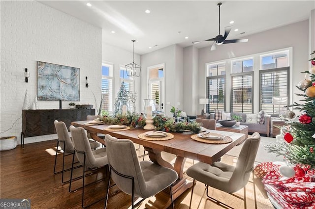 dining space with dark hardwood / wood-style floors and ceiling fan with notable chandelier