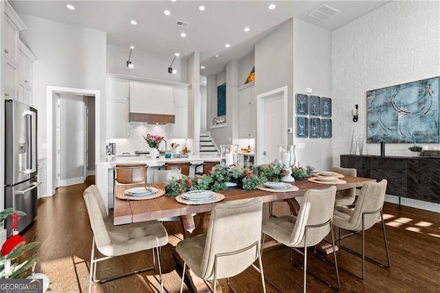 dining area featuring dark hardwood / wood-style floors and a high ceiling