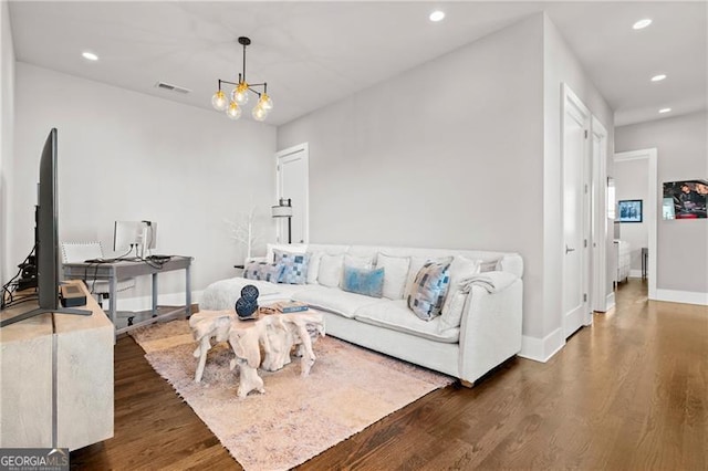 living room with dark wood-type flooring and an inviting chandelier