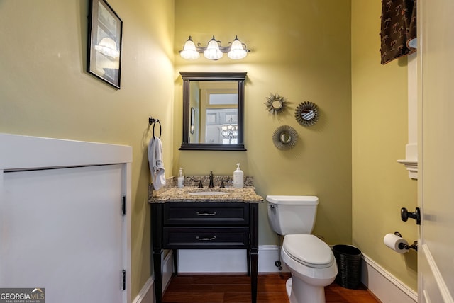 bathroom with hardwood / wood-style floors, vanity, and toilet