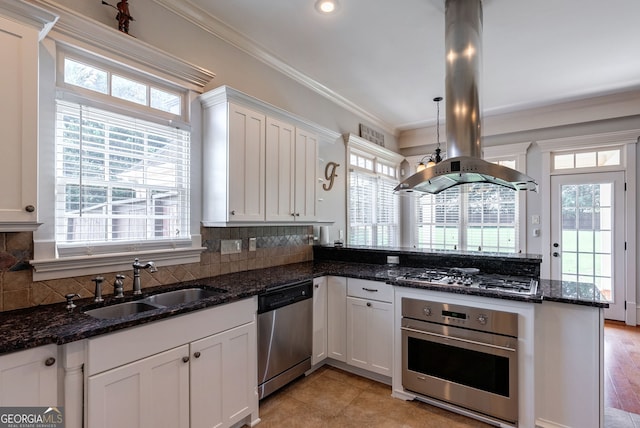 kitchen with island exhaust hood, stainless steel appliances, sink, pendant lighting, and white cabinetry