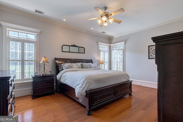 bedroom with multiple windows, light wood-type flooring, ceiling fan, and ornamental molding