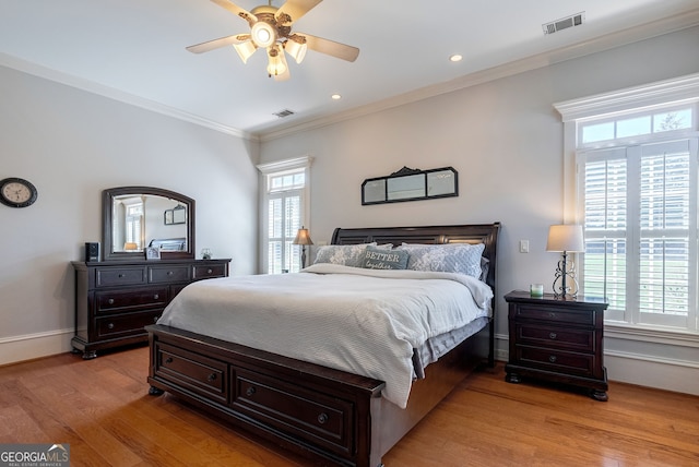 bedroom with ceiling fan, light hardwood / wood-style floors, and multiple windows